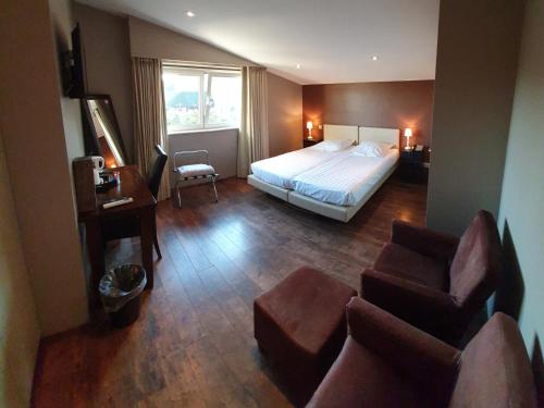 Habitación de hotel con cama y sofá en B&B De Edelsteen, en Zutendaal