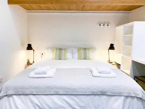 セビリアにあるStunning Boutique - Space Maison Apartmentsのベッドルーム1室(白いベッド1台、タオル2枚付)