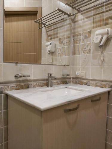 W łazience znajduje się umywalka i lustro. w obiekcie VeraNda w mieście Tbilisi City