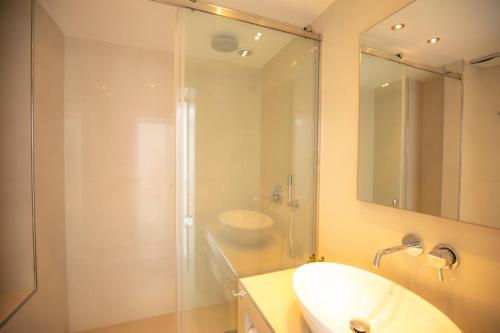 a bathroom with a sink and a glass shower at Santorini View Studios - Firostefani Caldera in Firostefani