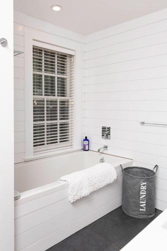 a white bathroom with a tub and a window at Seven Resort Style Inn near Beach in Shelter Island Heights