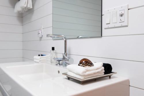 a bathroom sink with towels and a mirror at Seven Resort Style Inn near Beach in Shelter Island Heights