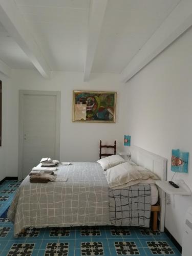 ein Schlafzimmer mit einem Bett in einem weißen Zimmer in der Unterkunft Il giardino di Don Peppino in Oristano