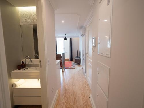 a white bathroom with a sink and a mirror at Augusta 229-5E-City Center Apt- Balcony & Elevator in Lisbon