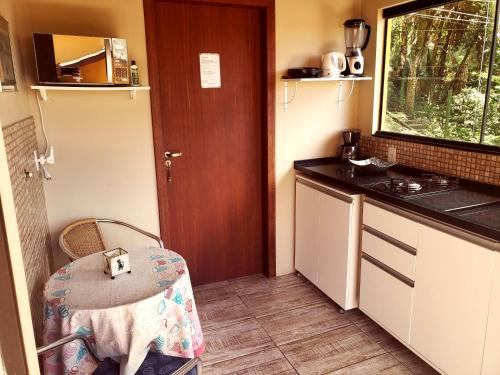 a small kitchen with a sink and a table at Plumeria Guest House in Florianópolis