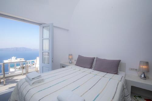 a bedroom with a bed with a view of the ocean at Santorini View Studios - Firostefani Caldera in Firostefani