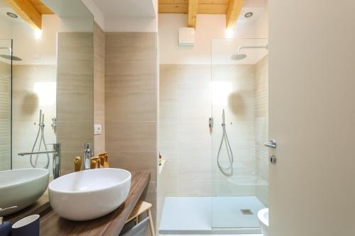 une salle de bain avec deux lavabos et une douche dans l'établissement Altana Bergamo Home, à Bergame