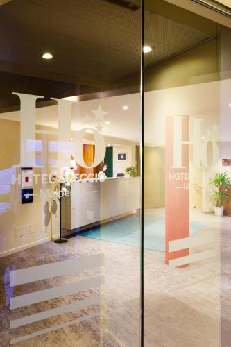 a lobby of a hotel with a reflection in the glass at Hotel Oleggio Malpensa in Oleggio
