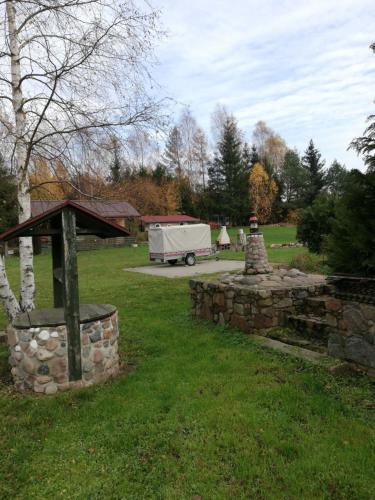 a stone wall in a yard with a truck in the background at Pod Sową in Drawsko Pomorskie
