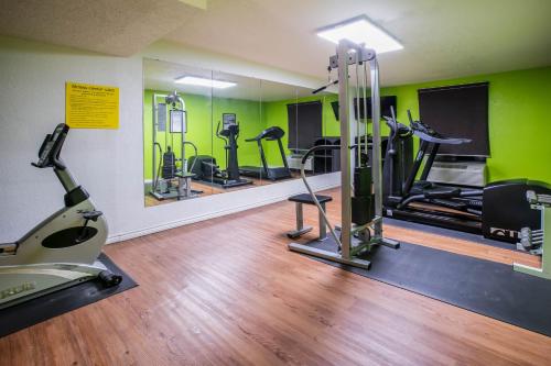 a gym with treadmills elliptical machines and green walls at Super 8 by Wyndham Ft Stockton in Fort Stockton