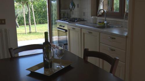 a bottle of wine and a glass on a table in a kitchen at Residence Colle Veroni in Mosciano SantʼAngelo