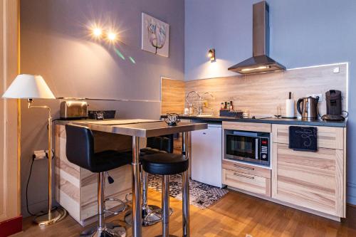 une cuisine avec un comptoir et une table avec des tabourets dans l'établissement La Villa, à Rouen