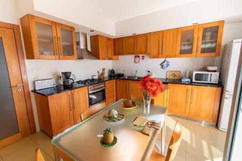 a kitchen with a table with a vase of flowers on it at Apartment T3 in Downtown with Sea View in Ponta Delgada