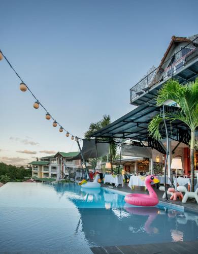 a pool at a resort with inflatable flamingos in the water at La Suite Villa in Les Trois-Îlets