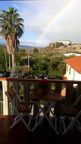 a table and chairs on a balcony with a rainbow at La Dimora Degli Artisti in Catanzaro