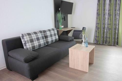 a living room with a black couch and a table at Hotel Landgasthof Linde in Nürtingen