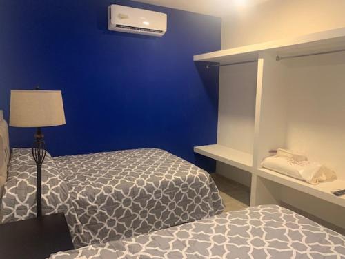 a bedroom with a bed and a blue wall at LOMAS SUITES in Ciudad Valles