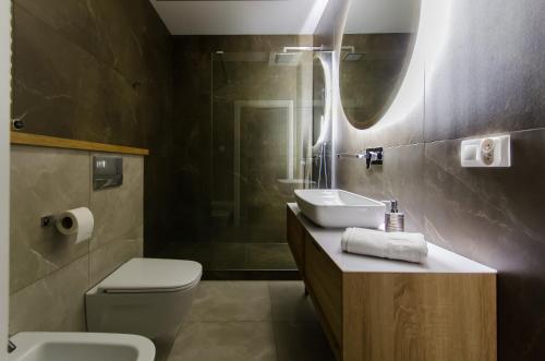 La salle de bains est pourvue de toilettes, d'un lavabo et d'une douche. dans l'établissement Krakowiak Apartments, à Cracovie