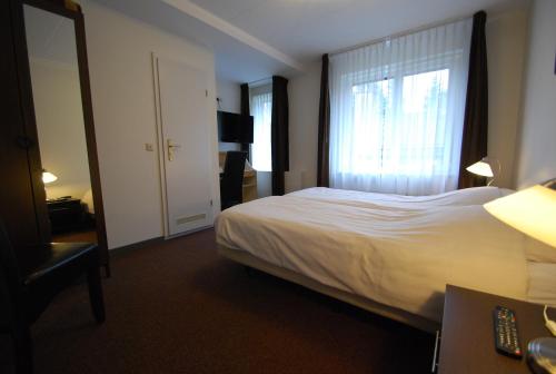 a hotel room with a bed and a window at Boutique Hotel de Rozenhof in Heilig Landstichting