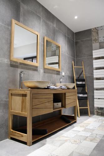 een badkamer met een wastafel en 2 spiegels bij A l'orée du château in Achy