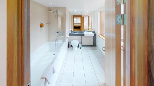 uma casa de banho com um chuveiro, um WC e um lavatório. em College Court Hotel em Leicester
