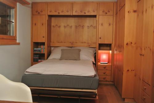a bedroom with a bed in a wooden cabinet at Chalet Studio - Top Ausstattung - beste Lage Davos in Davos