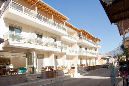 a large white building with tables and chairs at Grand TheoNi Boutique Hotel & Spa in Vasiliki