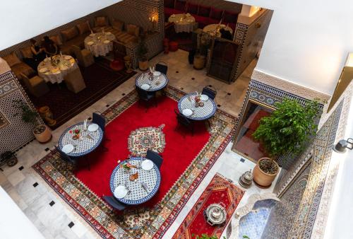 an overhead view of a restaurant with tables on a red rug at Riad Al Makan Fes & Spa in Fès