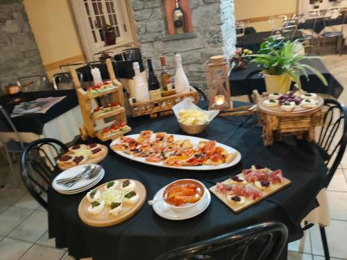 Locanda mami في أَويستا: طاولة سوداء مع أطباق من الطعام عليها