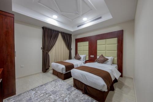 a hotel room with two beds in a room at شقق حديقة الزهور 2 للشقق المخدومة in Yanbu