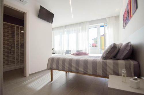 ein Schlafzimmer mit einem Bett und einem großen Fenster in der Unterkunft VARESE COMFORT ROOM in Varese