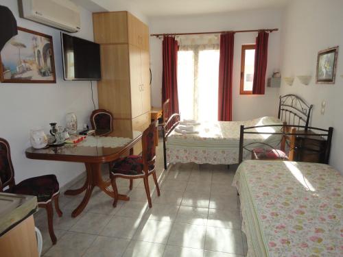 Zimmer mit 2 Betten, einem Tisch und einem Schreibtisch in der Unterkunft Villa Elizea in Stalós