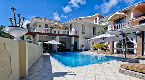 a villa with a swimming pool and a house at Carana Hilltop Villa Seychelles in Glacis