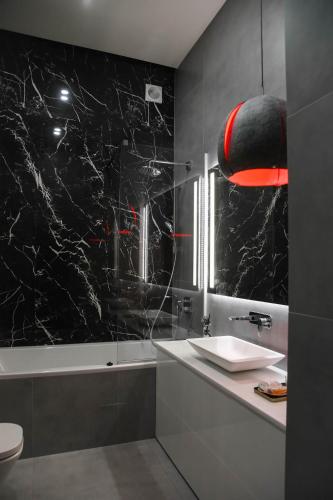 a bathroom with a sink and a mirror at Apart Hotel на Трояндовой in Chernivtsi