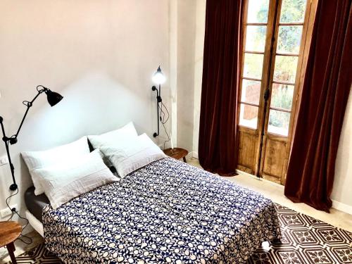 a bedroom with a bed with a blue and white blanket at VILLA CAMPANA - Bastia centre in Bastia