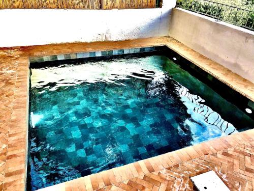 d'une piscine avec du carrelage et de l'eau bleue. dans l'établissement VILLA CAMPANA - Bastia centre, à Bastia
