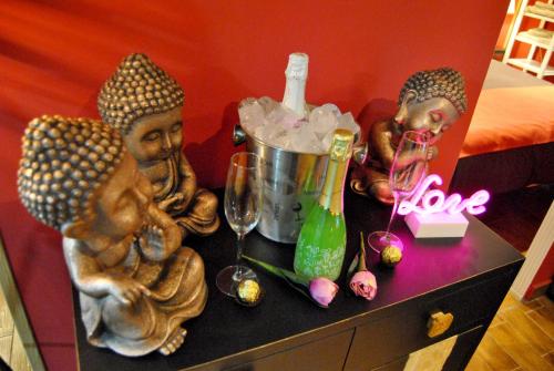 a table with two statues and wine glasses on it at Apartahotel Rural CollaRubio Luxury in Collado Mediano