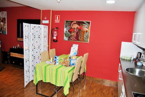 a table in a kitchen with a red wall at Apartahotel Rural CollaRubio Luxury in Collado Mediano