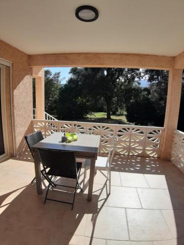 une table et des chaises assises sur une terrasse dans l'établissement maison Inseme, à Pietracorbara