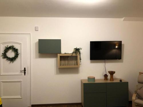 ein Wohnzimmer mit einem Flachbild-TV an der Wand in der Unterkunft Ferienwohnung Stadtflair in Daun