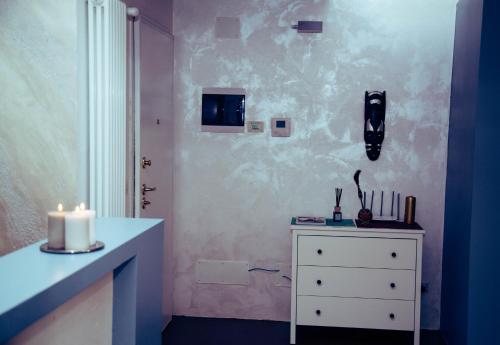 ein Zimmer mit einer weißen Kommode mit einer Kerze darauf in der Unterkunft CASA DI ATOS fiera district in Bologna