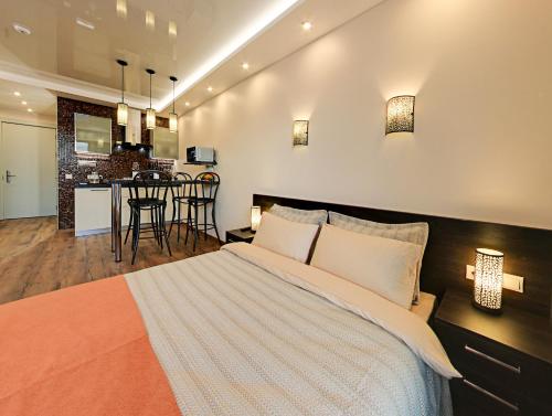 a bedroom with a large bed and a kitchen at Amber DeLUX Atrium-Neo, New Gudauri in Gudauri