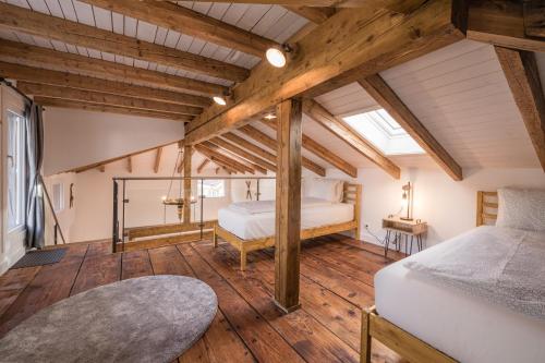 a bedroom with two beds and wooden floors at 2 Bedroom Mountain View Apartment Interlaken in Interlaken