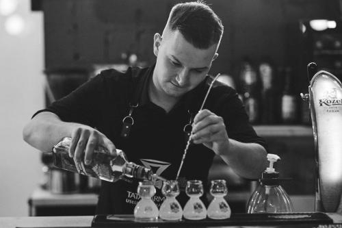 Een man maakt een drankje in een bar. bij Parkova - pokoje hotelowe in Gołdap