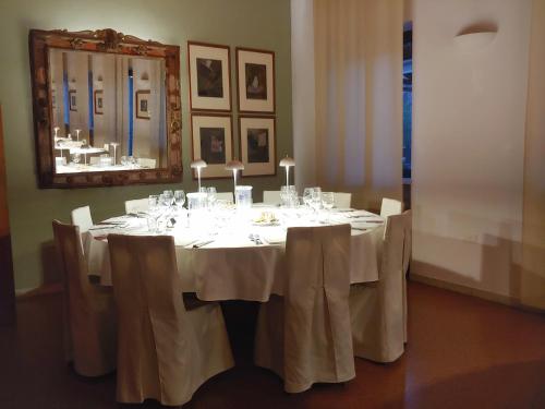 jadalnia ze stołem, krzesłami i lustrem w obiekcie LOCANDA PERINELLA w mieście Castelgomberto