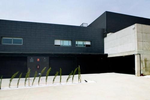a black and white building with palm trees in front of it at Shhh in Onda