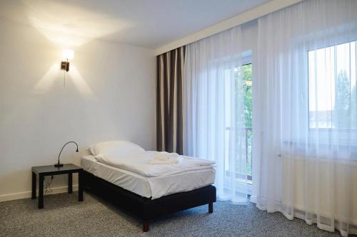 sypialnia z łóżkiem i dużym oknem w obiekcie Parkova - pokoje hotelowe w Gołdapi