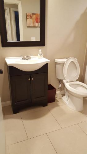 ein Badezimmer mit einem Waschbecken, einem WC und einem Spiegel in der Unterkunft Beautiful 3 bed/2 Bath Cozy Get Away Home in Las Vegas