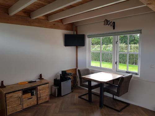 a dining room with a table and a window at De Cromvoirtse Bed and Breakfast in Cromvoirt