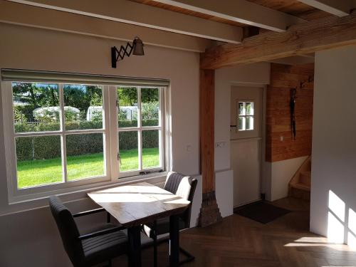 a dining room with a table and a window at De Cromvoirtse Bed and Breakfast in Cromvoirt
